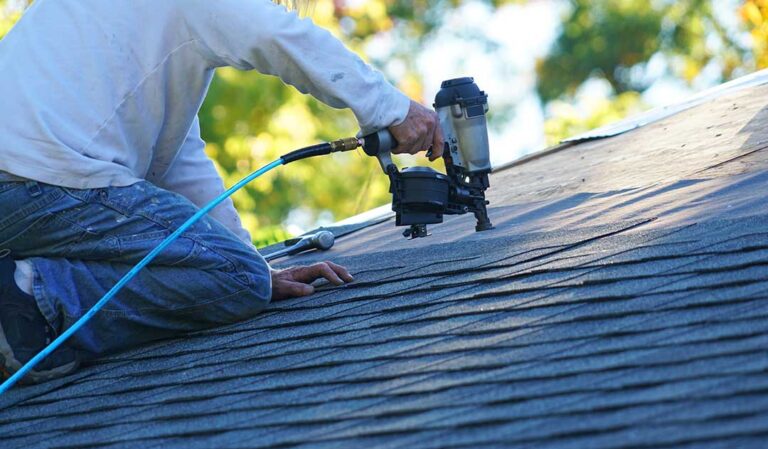 Homeowner sorts asphalt shingles, metal flashing, and roofing debris into separate covered containers.